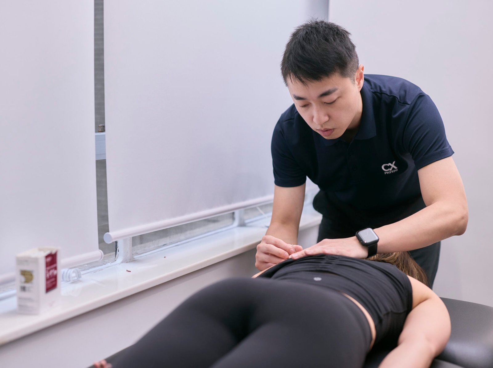 Gary Ng precisely applying a modern acupuncture needle to the shoulder complex to release muscle tension and restore mobility.